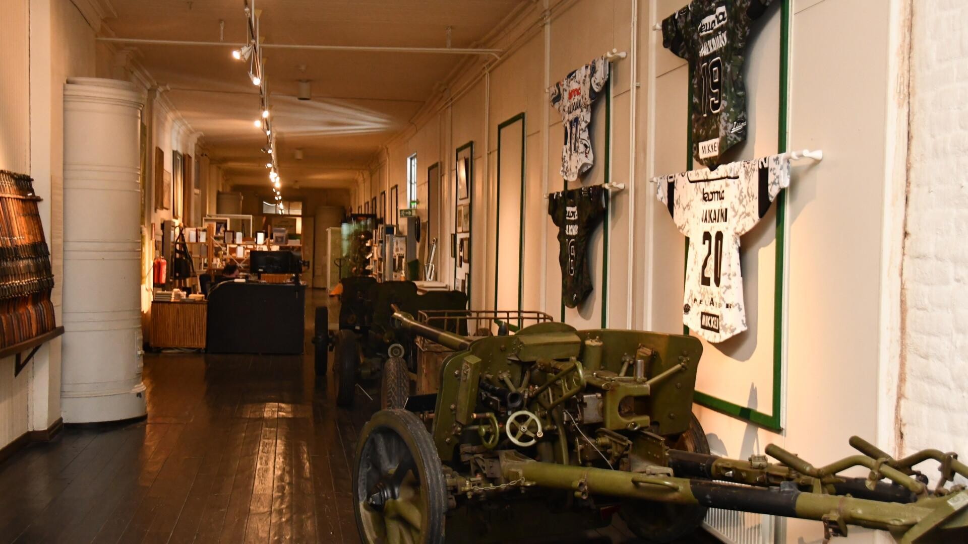 Kuva Jalkaväkimuseosta sisällä, edustalla vanhaa kalustoa ja seinillä roikkuu paitoja