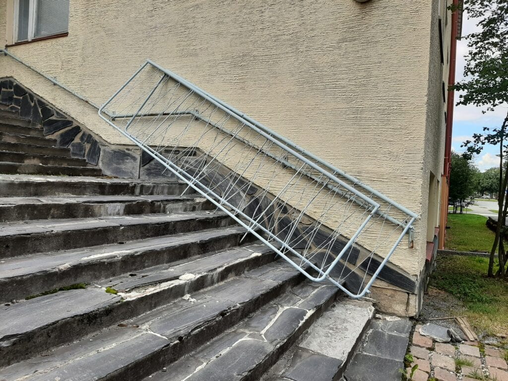 Metalliset kaiteet nojaavat rakennuksen seinää vasten.