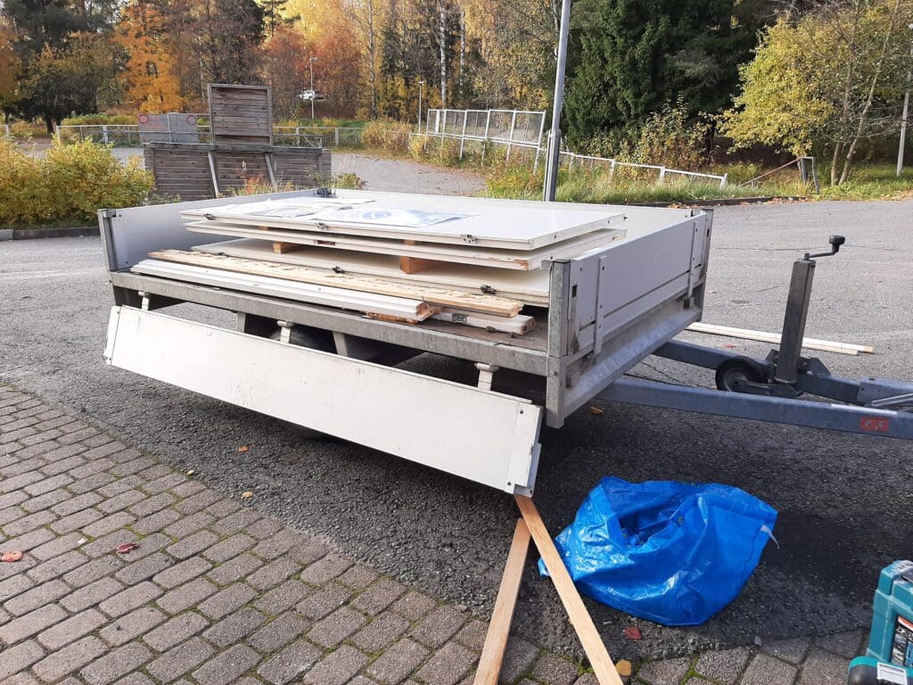 Kuvassa vaaleita puuväliovia karmeineen lastattuna peräkärryn kyytiin.