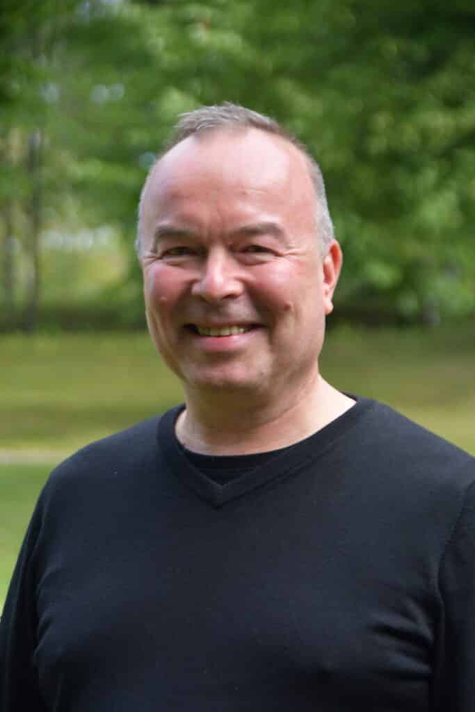 Hymyilevä mies, taustalla vihreitä puita