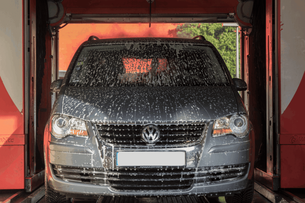 Kuvassa on harmaa auto autopesussa.