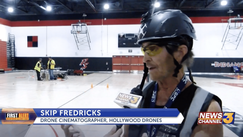 Mies kypärä päässä taustallaan urheiluhalli